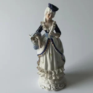Stojąca figurka porcelanowa kobiety w niebieskiej sukni ze złotymi zdobieniami.