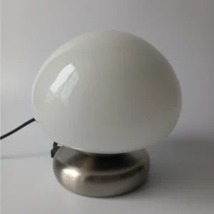 Lampa stołowa w kształcie grzybka, biały szklany klosz i metalowa noga.