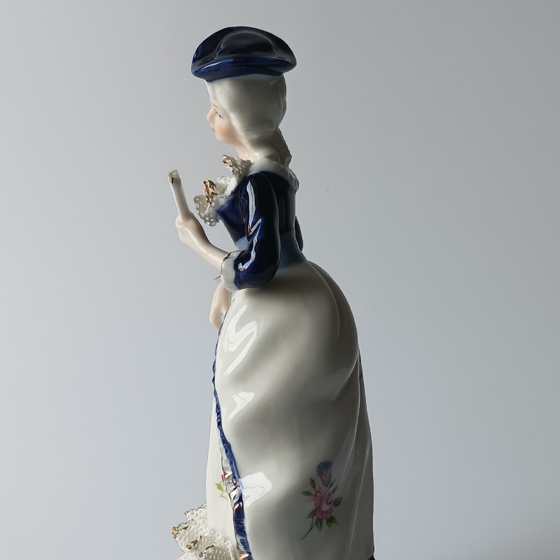 figurka porcelanowa dama dworu Widok z boku na figurkę damy dworu, detale malatury.