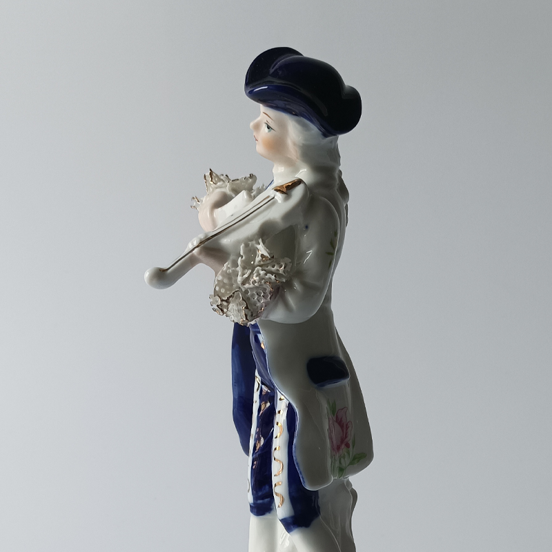 figurka porcelanowa dama dworu copy Widok z boku na figurkę skrzypka, widoczny trójgraniasty kapelusz i frak.