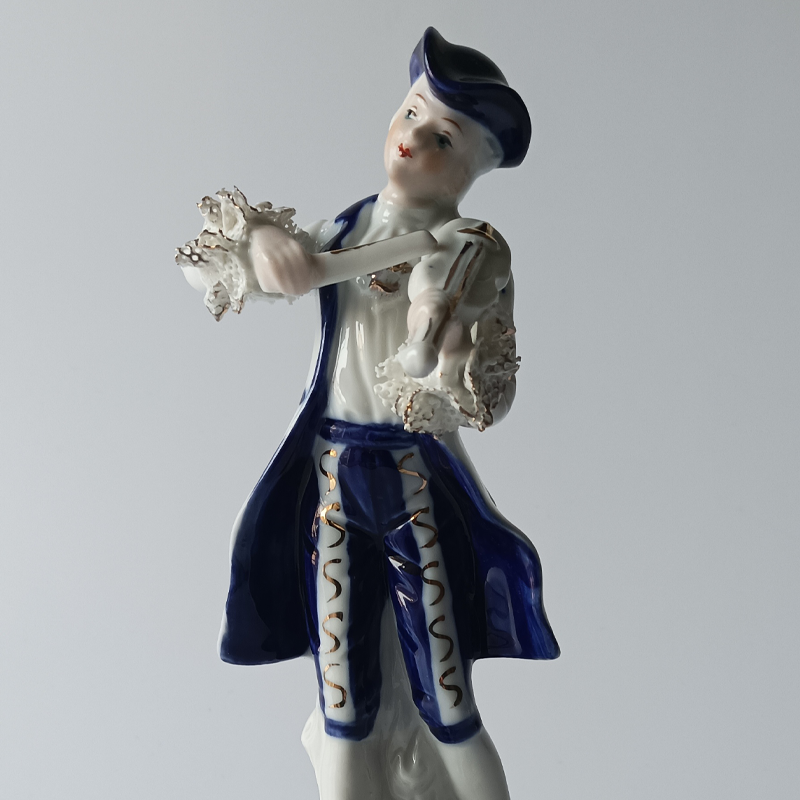 figurka porcelanowa dama dworu copy Muzyk w stroju z epoki rokoko, widoczne porcelanowe koronki przy mankietach.