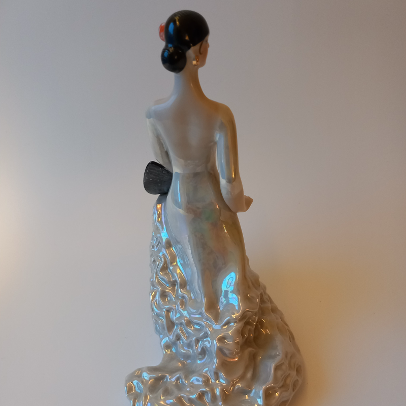 figurka porcelanowa „carmen” Tył figurki porcelanowej tancerki, widoczne falbany sukni i perłowy połysk.