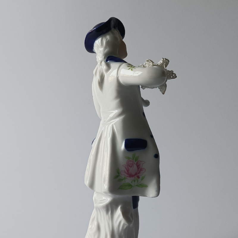 figurka porcelanowa dworski muzyk ze skrzypcami Tył figurki porcelanowej, oparcie o pieniek, kobaltowy frak.