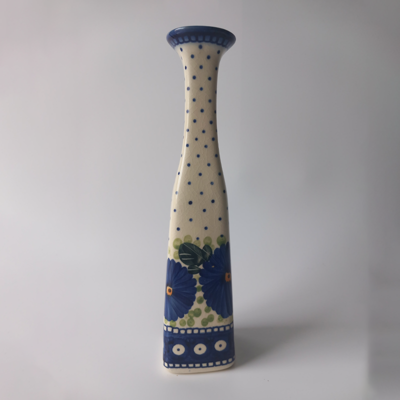 Smukły wazon ceramiczny Bolesławiec Galia, malowany w niebieskie kwiaty i kropki. Smukły wazon ceramiczny Bolesławiec Galia, malowany w niebieskie kwiaty i kropki.