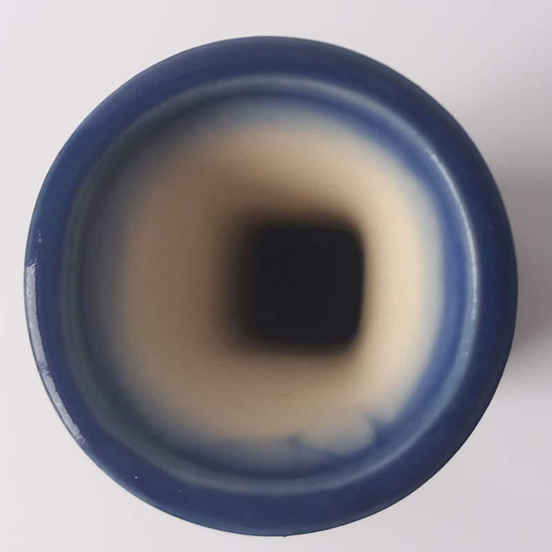 Smukły wazon ceramiczny Bolesławiec Galia, malowany w niebieskie kwiaty i kropki. Widok z góry na wlew wazonu, granatowy rant i szkliwione wnętrze.