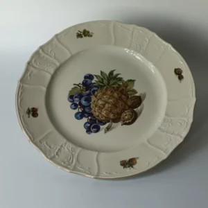 Duży porcelanowy talerz stołowy marki Bernadotte z motywem ananasa i winogron, widok z góry.