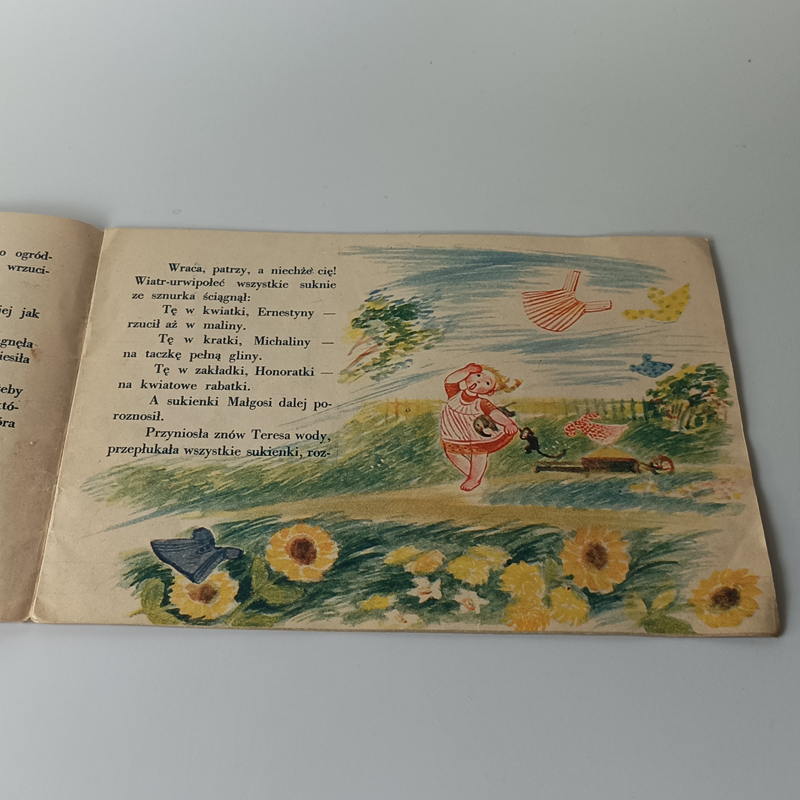 Książka „Pranie” H. Łochocka, Seria Poczytaj mi mamo – 1960 (Vintage) Wnętrze książki z wierszem Hanny Łochockiej i barwną ilustracją dziewczynki goniącej porwane przez wiatr ubrania.