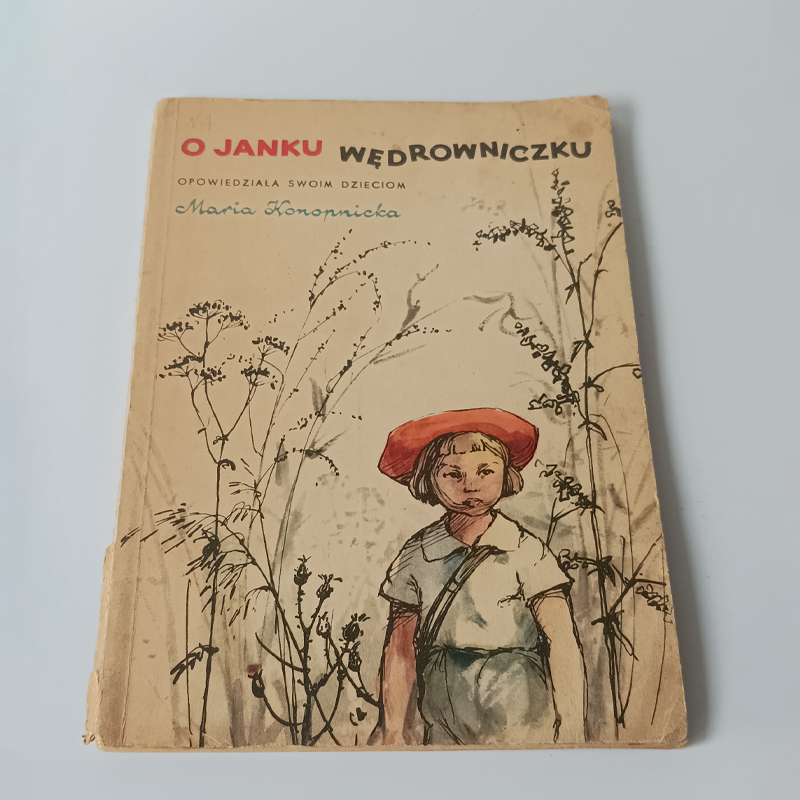 Książka „O Janku Wędrowniczku” Maria Konopnicka – Nasza Księgarnia 1958 (Vintage) Okładka książki O Janku Wędrowniczku Marii Konopnickiej, ilustracja chłopca w czerwonym berecie na tle polnych roślin.