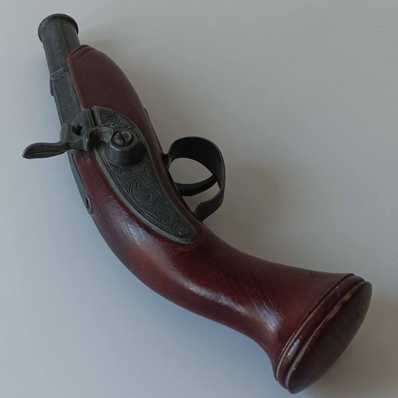 Kieszonkowy Pistolet Skałkowy – Ozdobna Replika Historyczna (23 cm) Prawy profil ozdobnego pistoletu kieszonkowego z widocznym mechanizmem skałkowym i roślinnymi grawerunkami.