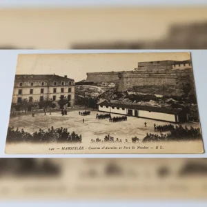 Stara pocztówka z 1912 roku przedstawiająca żołnierzy na placu koszar d'Aurelles i mury Fortu św. Mikołaja w Marsylii.