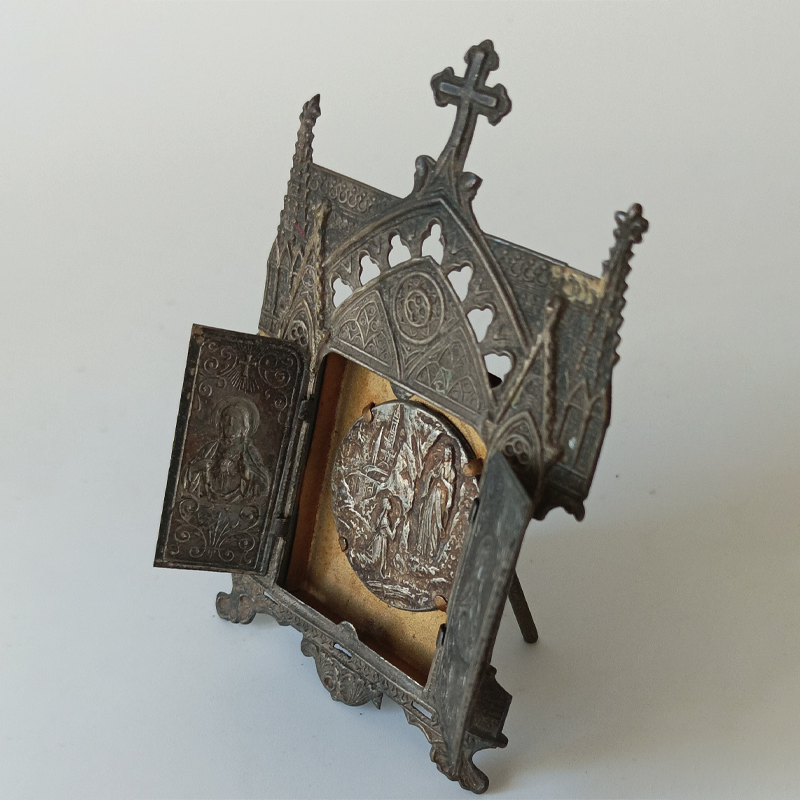 Neogotycki Ołtarzyk Podróżny (Tryptyk) – Objawienia z Lourdes (Vintage) Wnętrze miniaturowego ołtarzyka z metalu, widoczna klęcząca św. Bernadetta i Matka Boża w grocie.