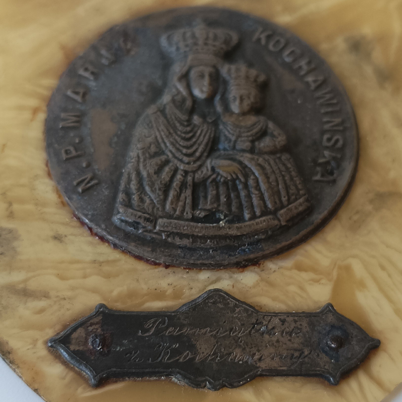 Przedwojenny Ryngraf „Matka Boska Kochawińska” – Celuloid, Pamiątka Kresowa (II RP) Zbliżenie na oksydowany metalowy medalion z napisem N.P. Marja Kochawińska na przedwojennym ryngrafie.