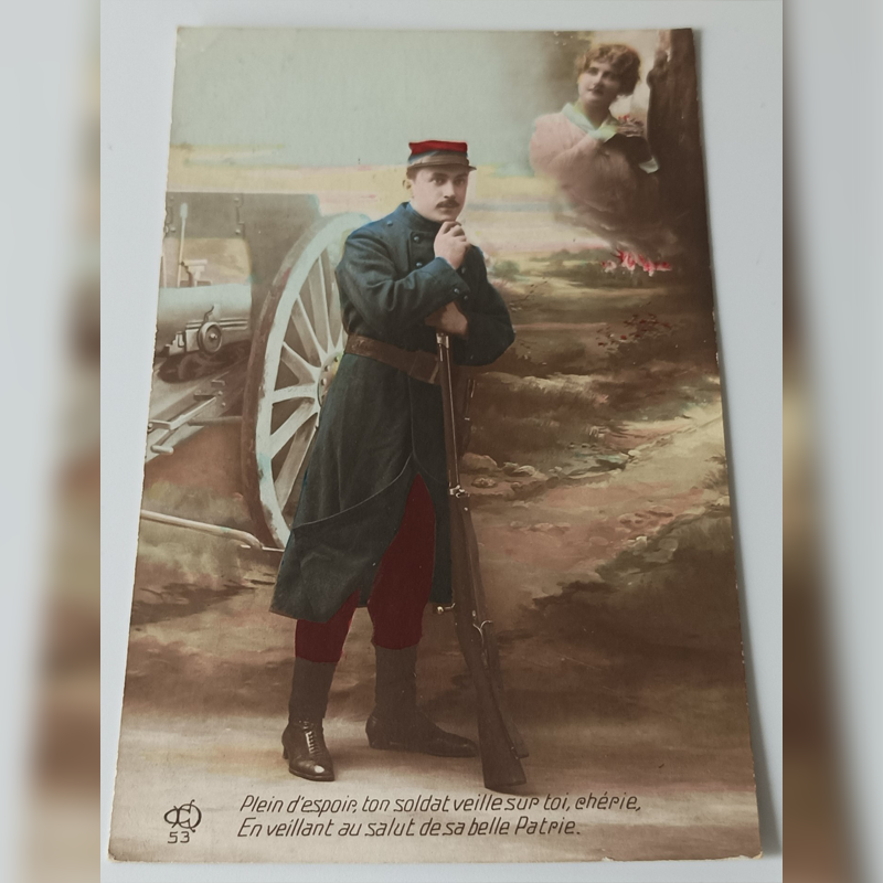 Pocztówka Patriotyczna (1915 r.) – „Czerwone Spodnie” i Artylerzysta (La Livinière) Kolorowana pocztówka z 1915 roku, francuski żołnierz w czerwonych spodniach przy armacie i wizja kobiety.