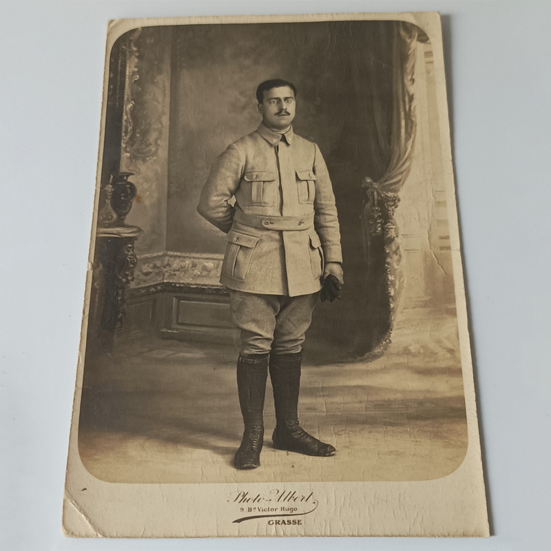 Portret Żołnierza z Grasse – Atelier „Photo-Albert” (I Wojna Światowa) Stara fotografia studyjna żołnierza francuskiego w mundurze z rękawiczkami, wykonana w atelier Photo-Albert w Grasse.