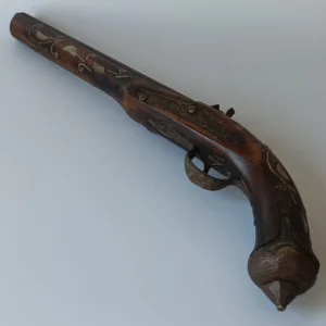 Ujęcie wzdłuż lufy pistoletu skałkowego ukazujące jego potężne proporcje i detale konstrukcyjne.