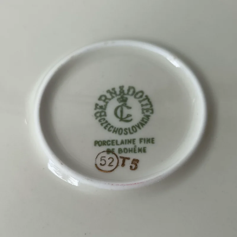 Duży porcelanowy talerz stołowy marki Bernadotte z motywem ananasa i winogron, widok z góry. Zielona sygnatura Bernadotte Czechoslovakia Porcelaine Fine de Bohême na spodzie talerza.