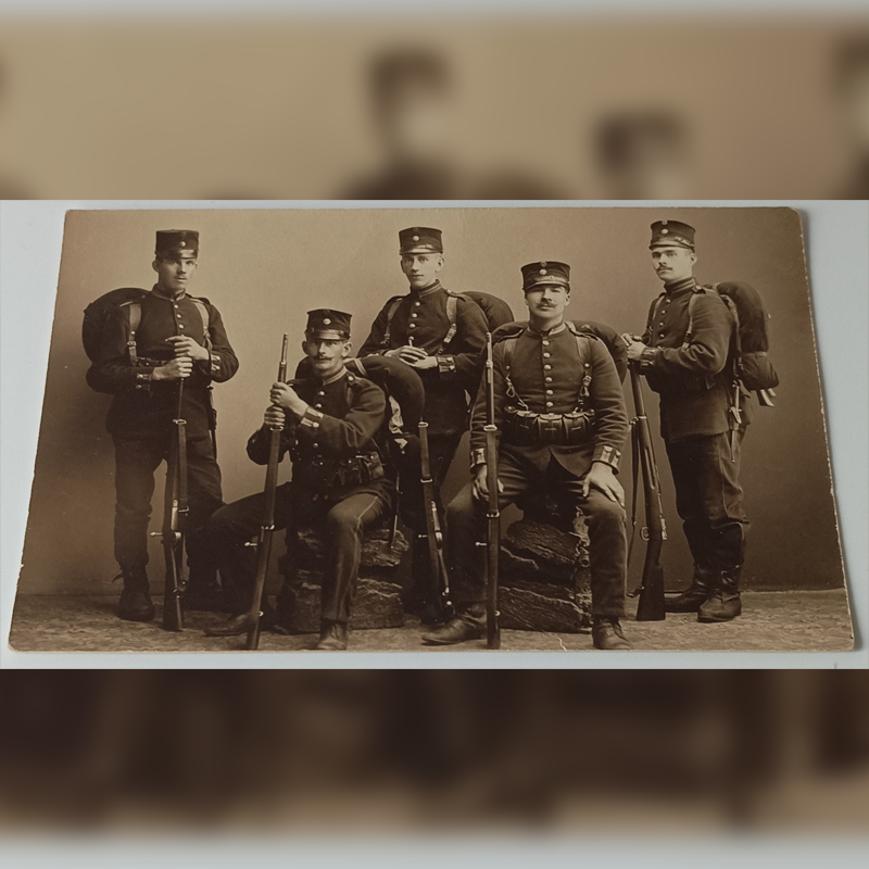 Fotografia Oddziałowa 1914 – Piechota Belgijska w Czakach (Unikat) Stara fotografia pięciu żołnierzy belgijskich z 1914 roku w czakach, z plecakami i karabinami Mauser.